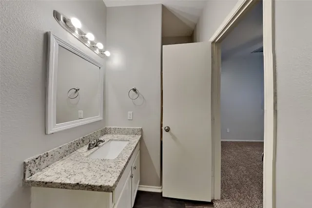 a bathroom with a granite countertop sink and a mirror