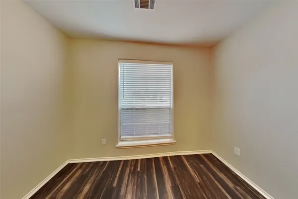 a view of a room with wooden floor and a window