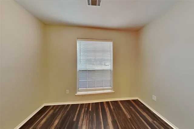 a view of a room with wooden floor and a window