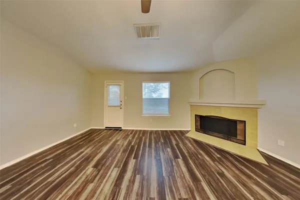 a view of empty room with wooden floor and fireplace