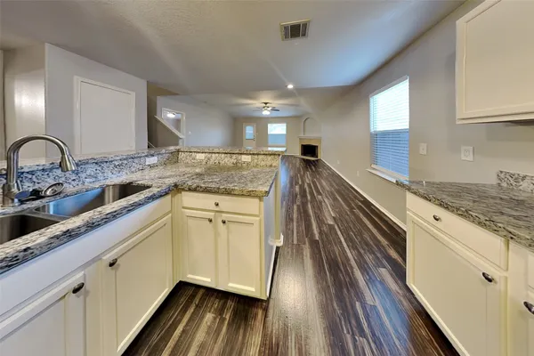a kitchen with granite countertop white cabinets and white appliances