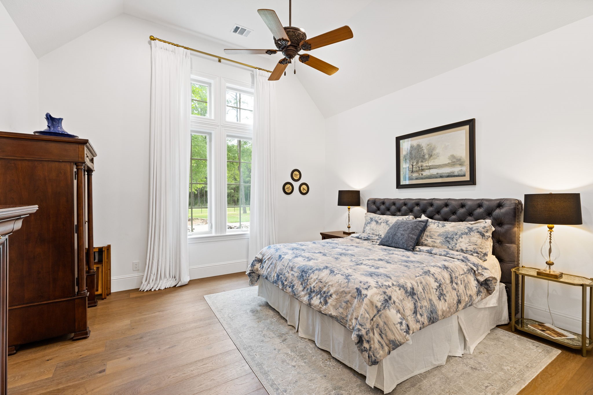 38223 Windy Ridge Trail Magnolia, TX 77355 - Photo 24 of 48 This spacious secondary bedroom features a vaulted ceiling, large windows with abundant natural light, and elegant hardwood floors, creating a warm and inviting atmosphere.