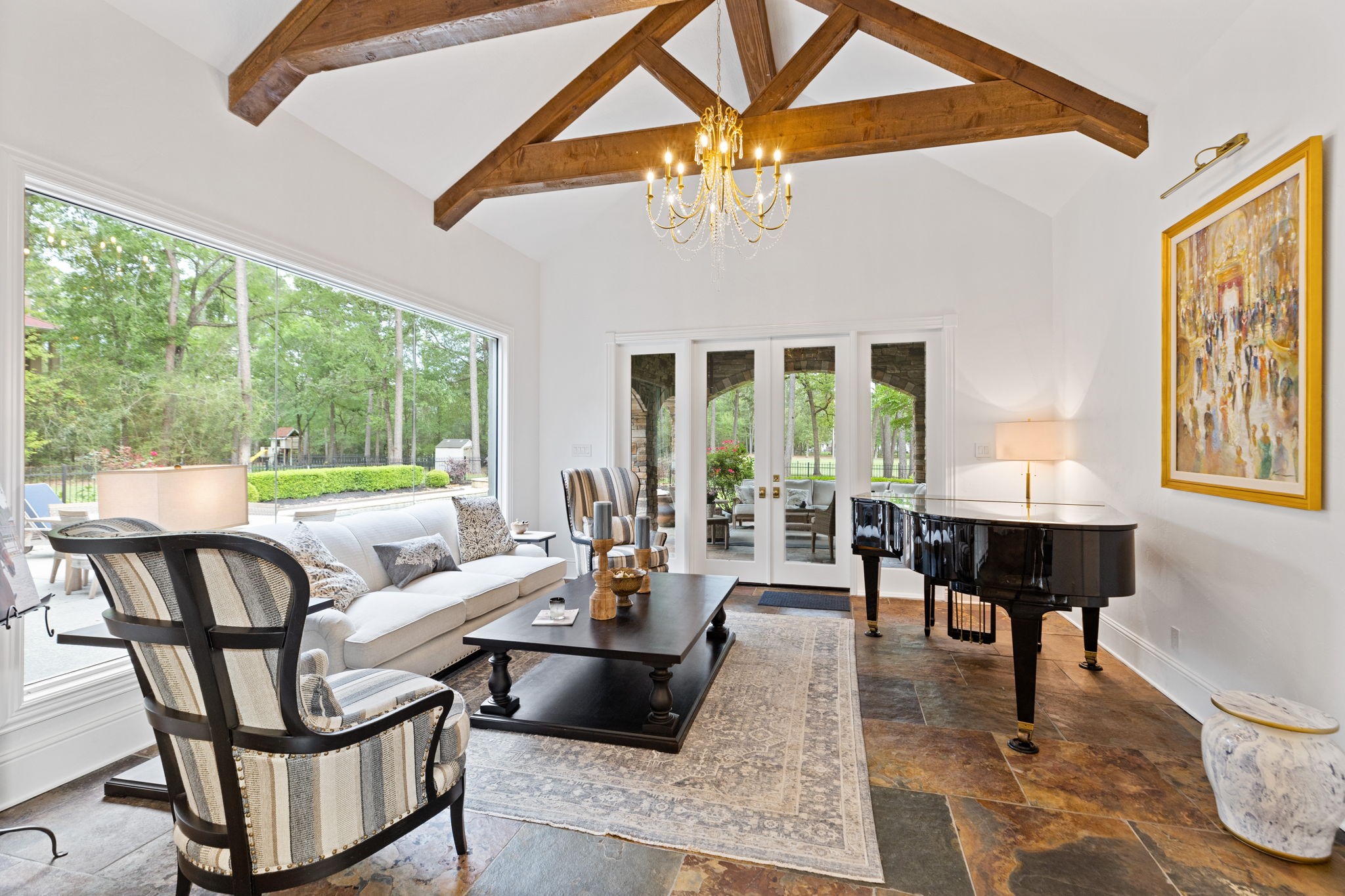 38223 Windy Ridge Trail Magnolia, TX 77355 - Photo 26 of 48 This inviting sun room features a high ceiling with exposed wooden beams, a large window offering scenic views, and abundant natural light. A stylish chandelier, creates a sophisticated yet cozy ambiance.
