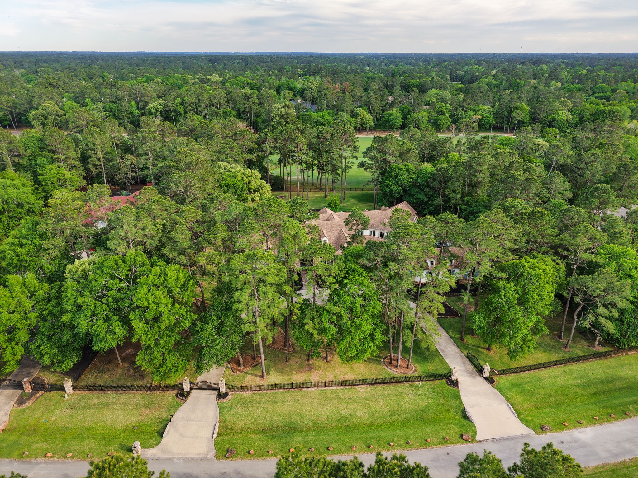 38223 Windy Ridge Trail Magnolia, TX 77355 - Photo 45 of 48 Nestled in a lush, wooded landscape, this expansive property offers privacy and tranquility. A long circular driveway leads to a charming home surrounded by mature trees, providing a serene escape and ample natural beauty.