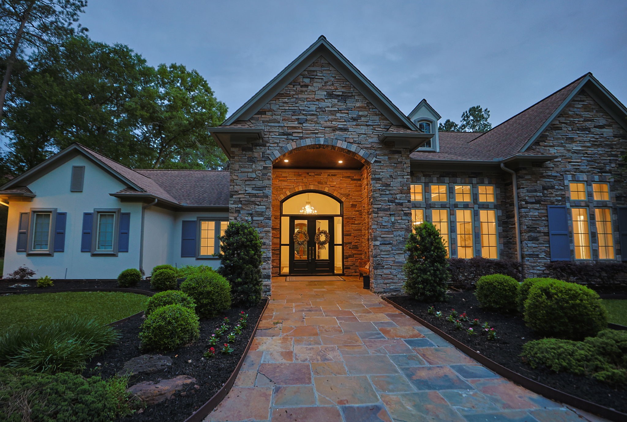 38223 Windy Ridge Trail Magnolia, TX 77355 - Photo 7 of 48 This sunset photo showcases a charming home with a welcoming front entrance. The large windows and manicured landscaping add to its curb appeal, creating an inviting atmosphere.