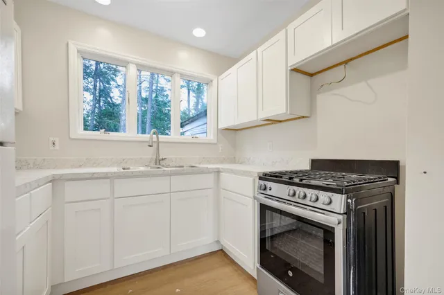 a kitchen with white cabinets and a stove top oven