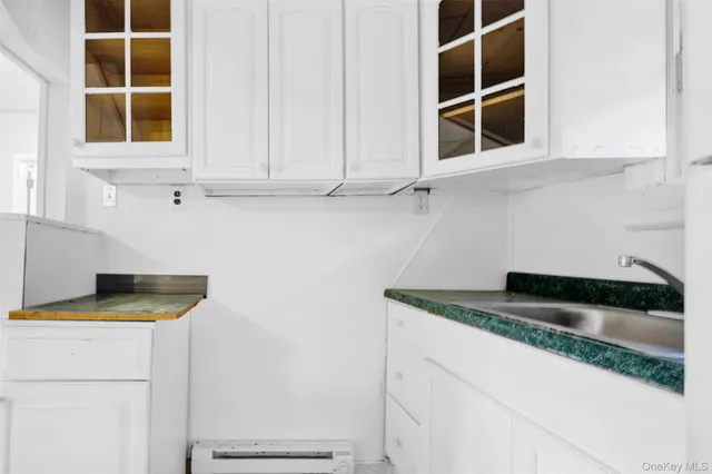 a kitchen with granite countertop white cabinets and a sink