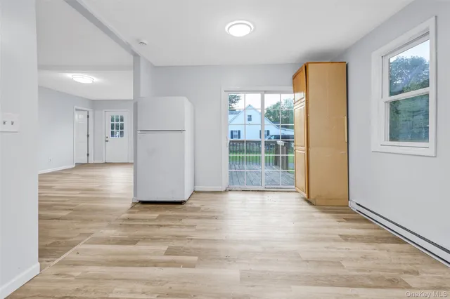 a view of a livingroom with wooden floor and a hallway
