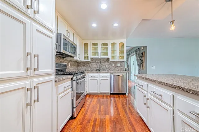 a kitchen with stainless steel appliances granite countertop a stove and cabinets