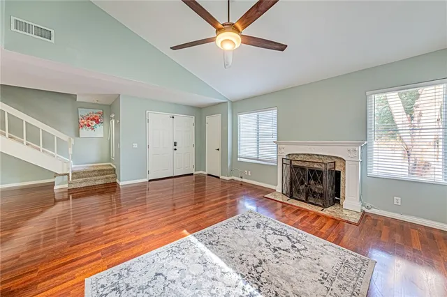 a view of a livingroom with wooden floor and a fireplace