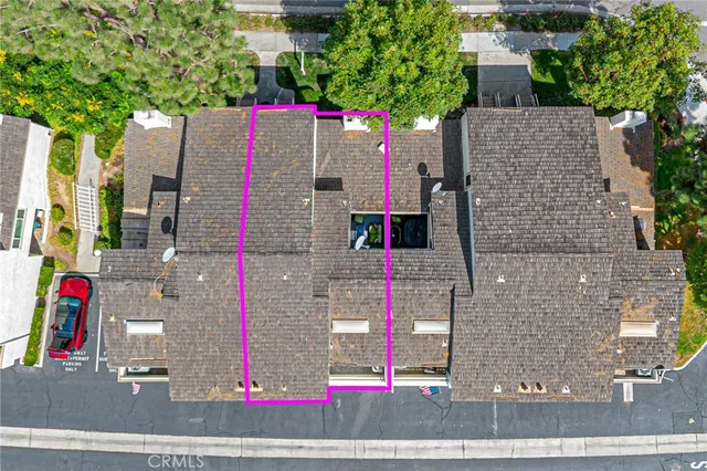 an aerial view of residential houses with outdoor space and trees