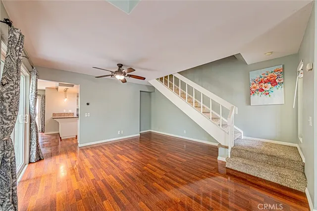 a view of a livingroom with wooden floor stairs