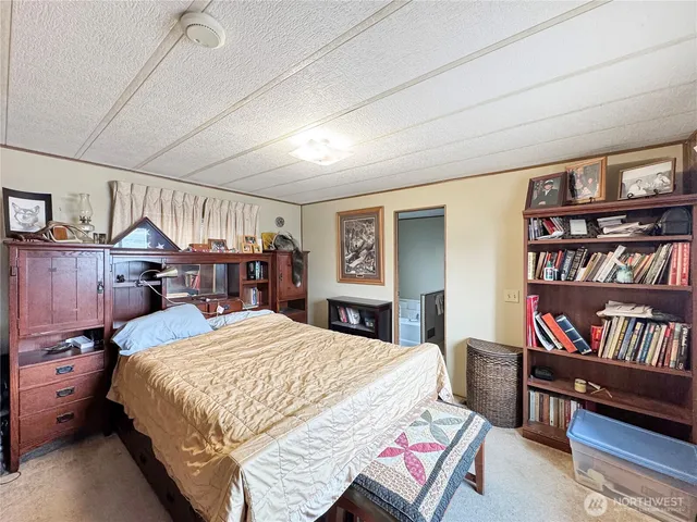 a bedroom with a bed a dresser and book shelf