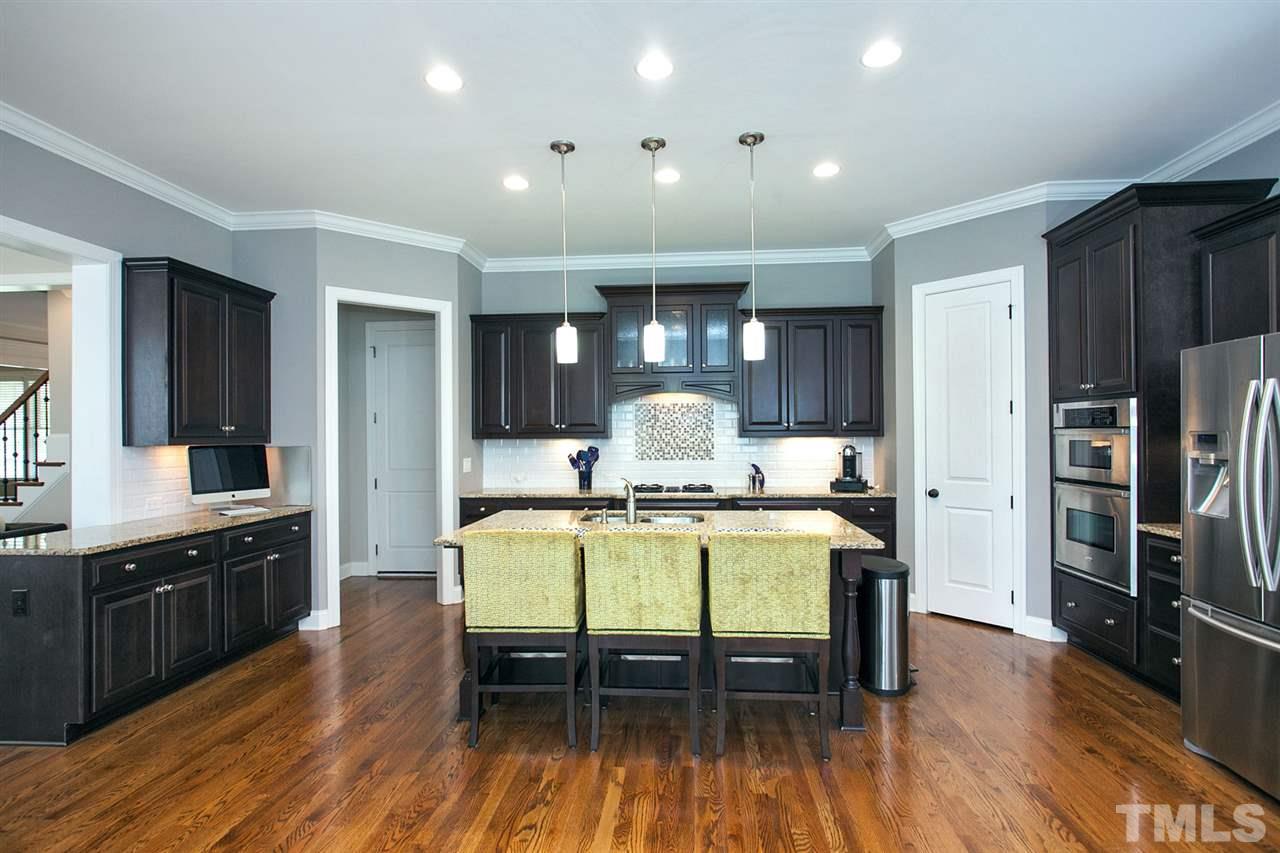 11818 Lowery Ridge Drive Raleigh, NC 27614 - Photo 3 of 25 Beautiful coffee colored, 42 in staggered raised panel cabinets with crown molding.