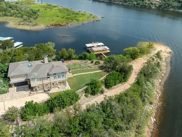 an aerial view of a house with a yard and lake view
