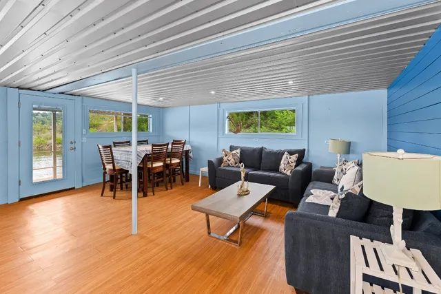 a living room with furniture a wooden floor and next to a window