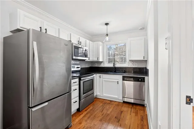 a kitchen with stainless steel appliances a refrigerator sink and microwave