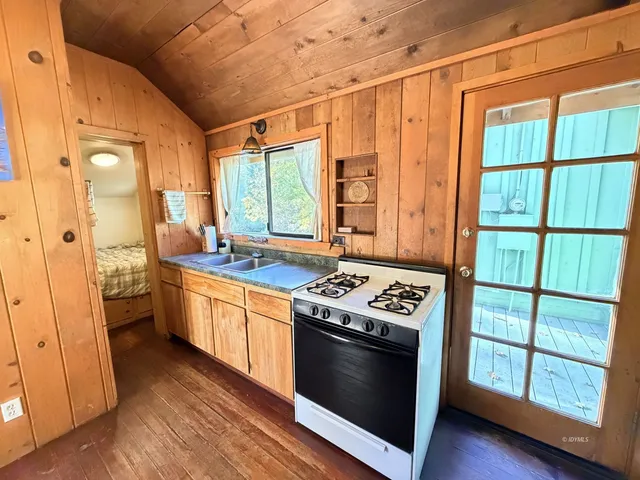 a kitchen with stainless steel appliances granite countertop a stove a refrigerator and a wooden cabinets