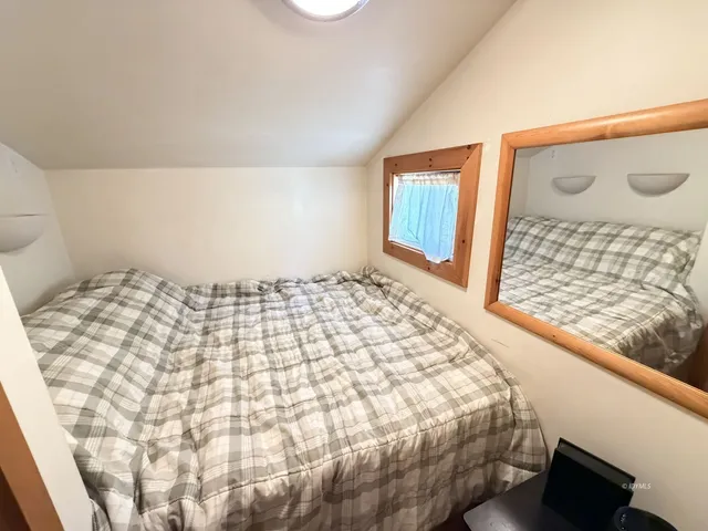 a large bed sitting in a bedroom next to a window
