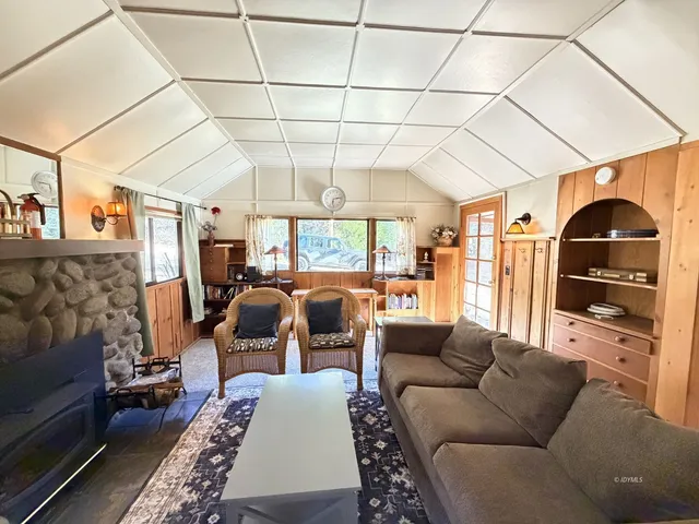 a living room with furniture a wooden floor and next to a window