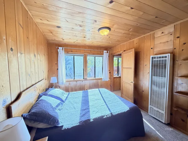 a bed sitting in a bedroom next to a window