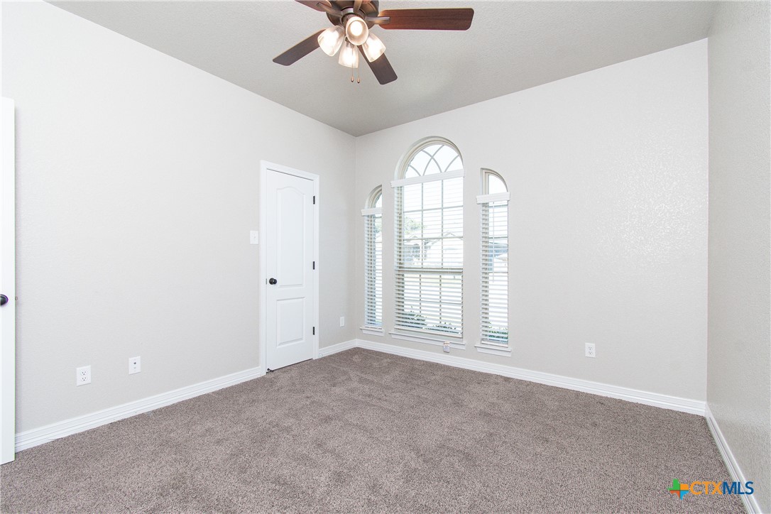 8101 Tenley Way Killeen, TX 76542 - Photo 19 of 29 an empty room with windows and chandelier fan