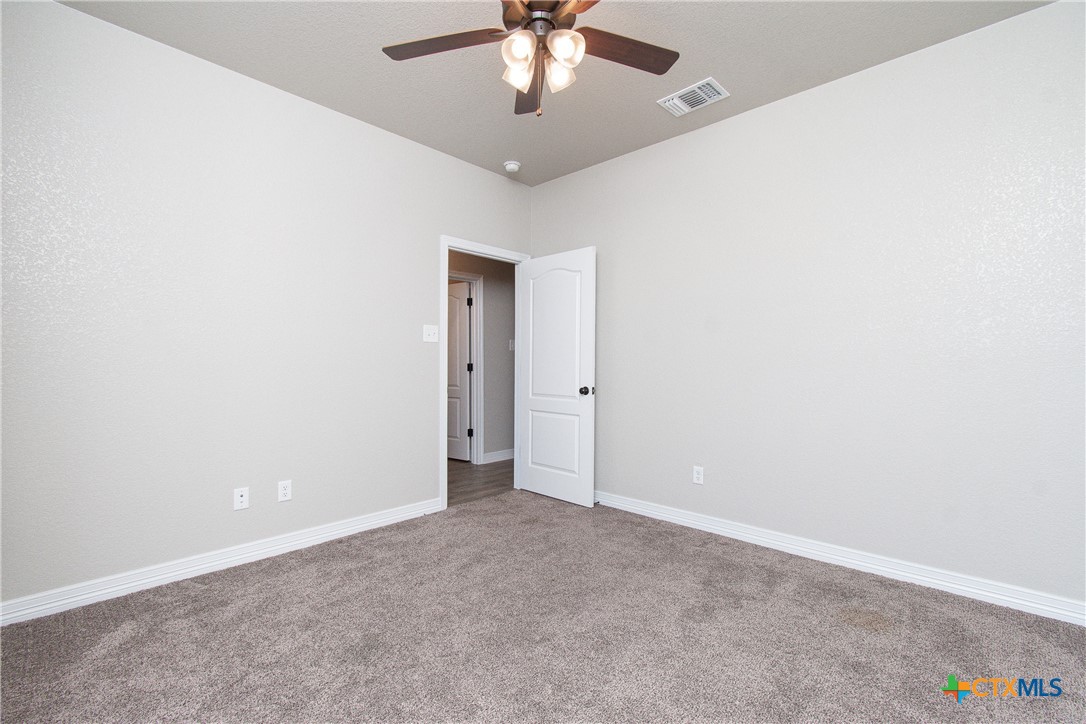 8101 Tenley Way Killeen, TX 76542 - Photo 22 of 29 an empty room with a chandelier fan and windows