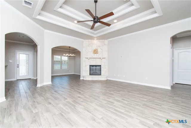 a view of a livingroom with a ceiling fan wooden floor and a ceiling fan