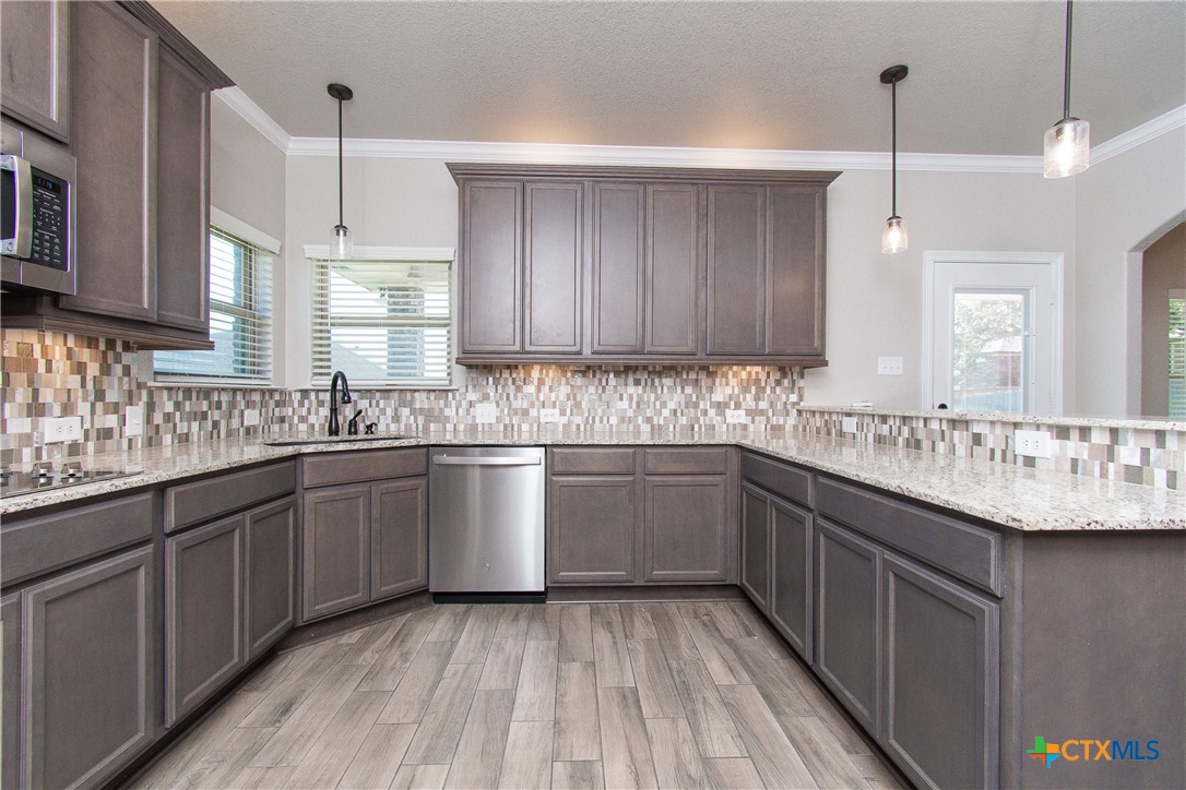 8101 Tenley Way Killeen, TX 76542 - Photo 10 of 29 a kitchen with granite countertop a sink cabinets and window