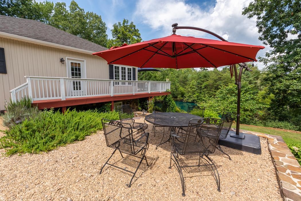 170 Old Back Road Raphine, VA 24472 - Photo 54 of 66 a backyard of a house with table and chairs under an umbrella
