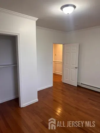 an empty room with wooden floor and closet