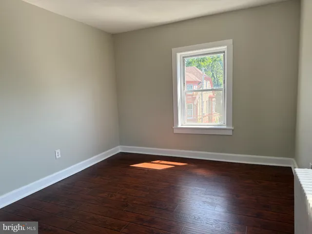 a view of a big room with wooden floor and windows