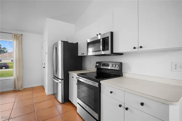 a kitchen with stainless steel appliances granite countertop a refrigerator stove and microwave