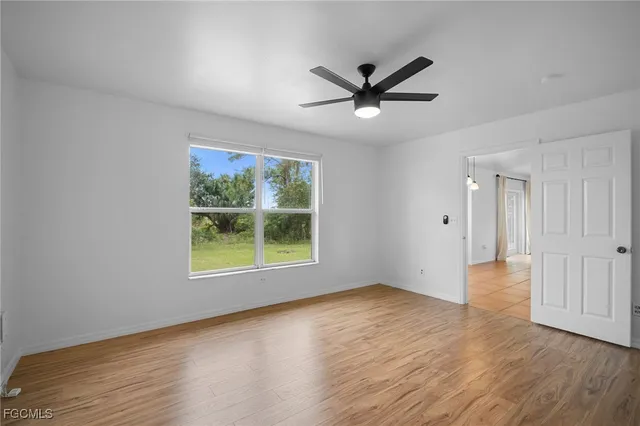 a view of a big room with wooden floor and windows