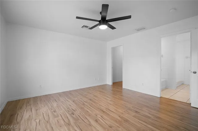 a view of a room with wooden floor and a ceiling fan