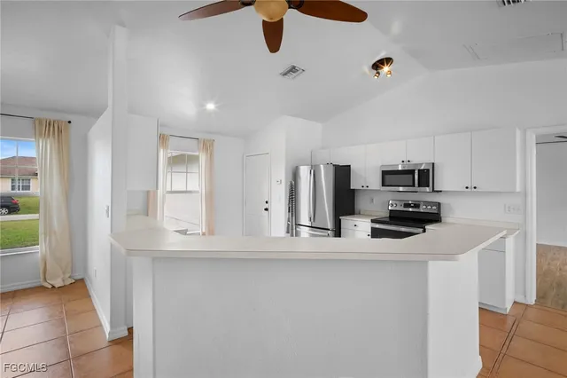 a kitchen with kitchen island stainless steel appliances a sink and refrigerator