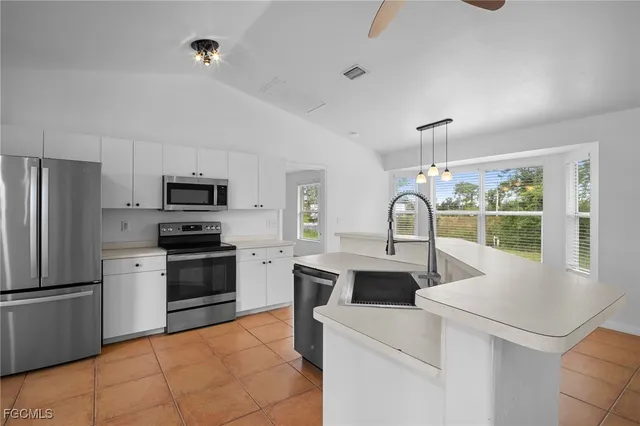 a kitchen with stainless steel appliances granite countertop a sink and a refrigerator