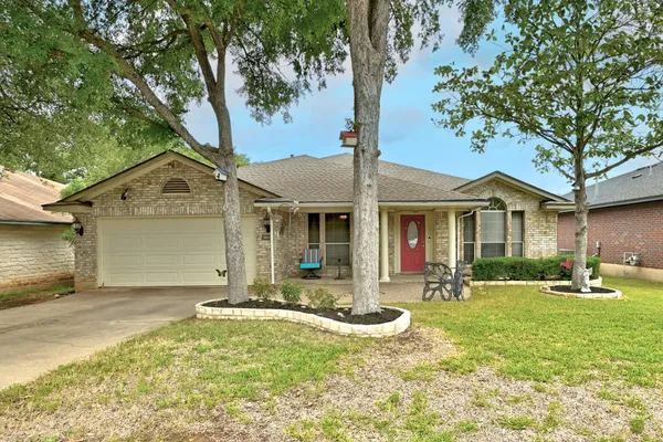 a front view of a house with a yard and tree