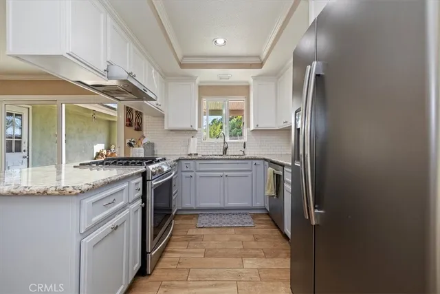 a kitchen with stainless steel appliances granite countertop a refrigerator and a sink
