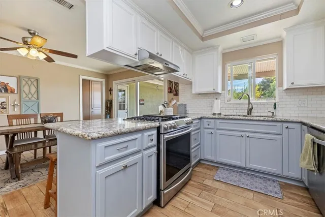a kitchen with stainless steel appliances granite countertop a sink and cabinets