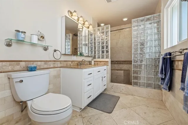 a bathroom with a granite countertop toilet sink and mirror