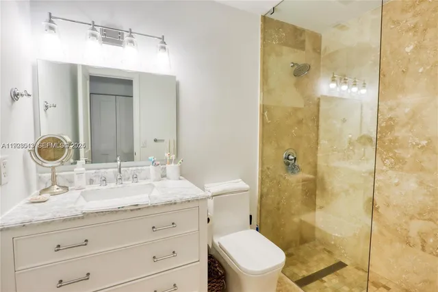 a bathroom with a granite countertop sink mirror toilet and shower