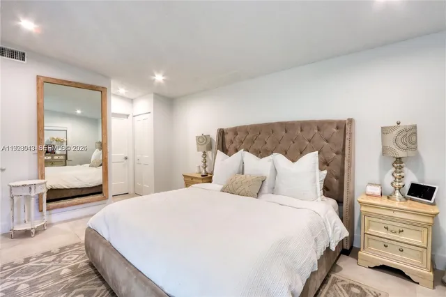 a bedroom with a bed and a large mirror