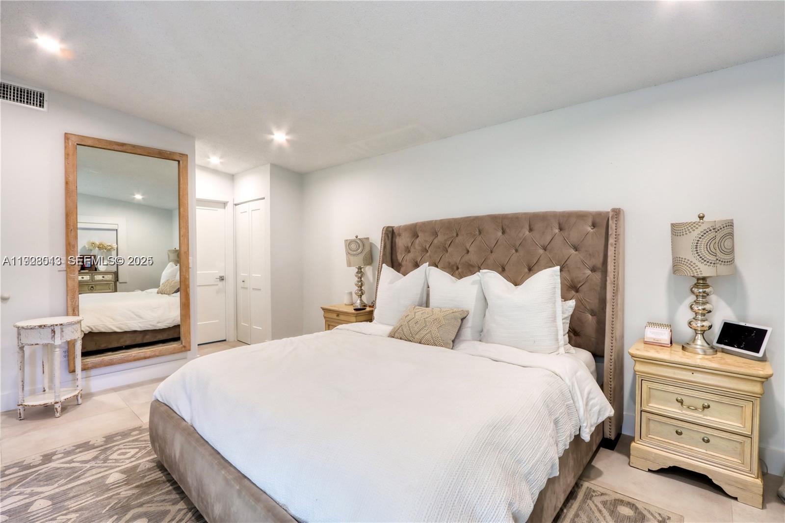 10478 Southwest 75th Lane, Unit 10478 Miami, FL 33173 - Photo 15 of 42 a bedroom with a bed and a large mirror