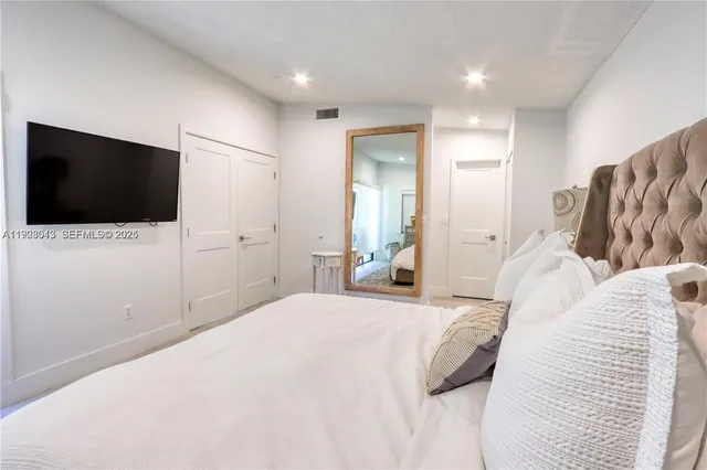 a bedroom with a bed and a flat screen tv