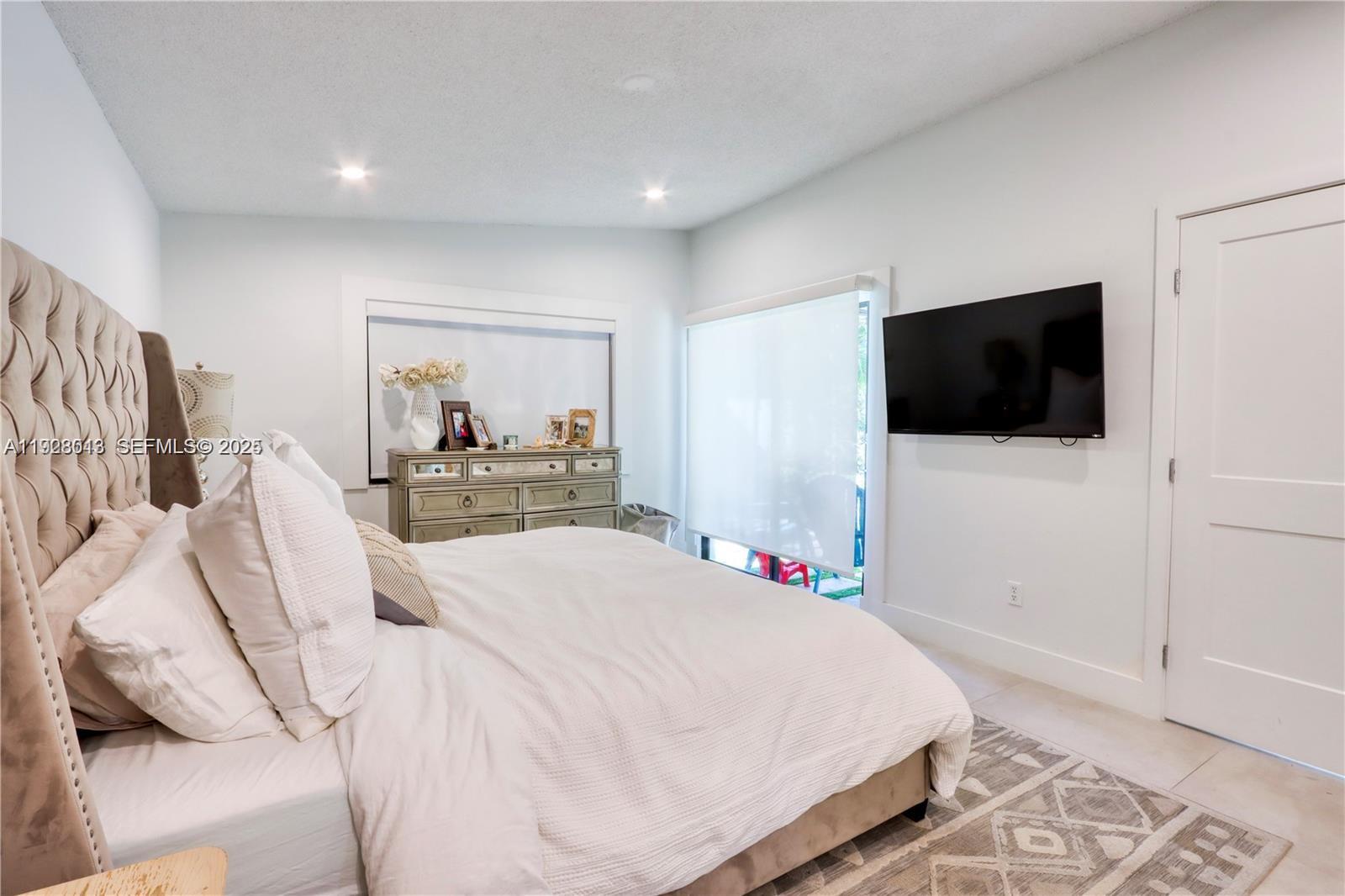10478 Southwest 75th Lane, Unit 10478 Miami, FL 33173 - Photo 17 of 42 a bedroom with a bed and a flat screen tv