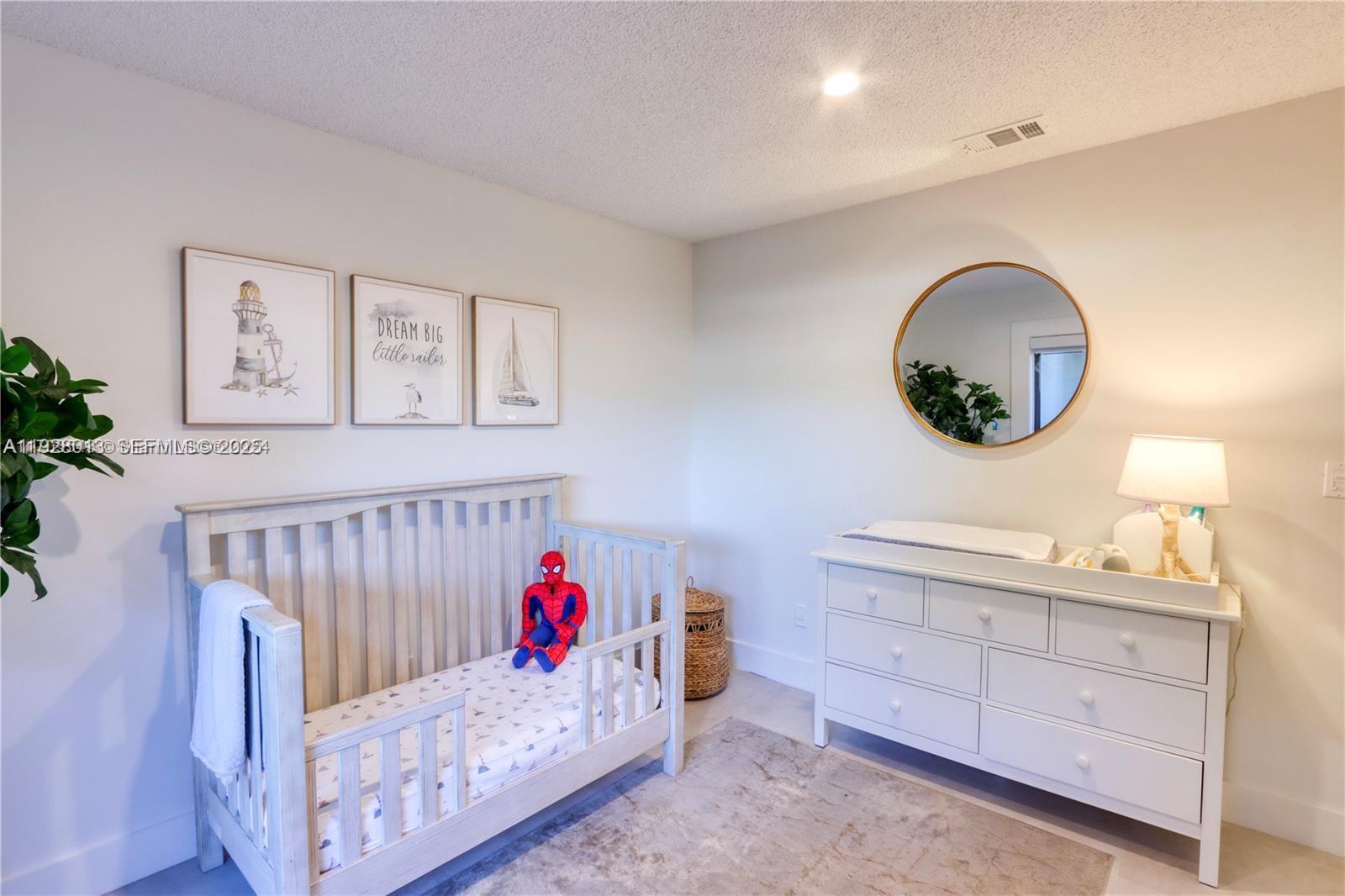 10478 Southwest 75th Lane, Unit 10478 Miami, FL 33173 - Photo 19 of 42 a bedroom with a bed and a chandelier