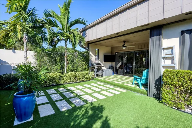 a view of a porch that has potted plants and a large tree