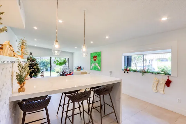 a view of a dining room and livingroom with furniture wooden floor a chandelier