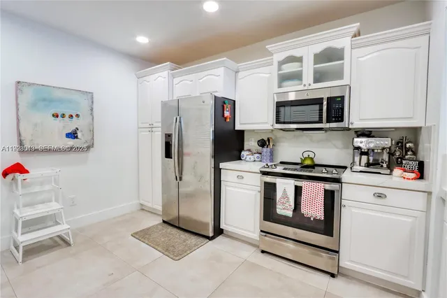 a kitchen with stainless steel appliances granite countertop a refrigerator and microwave